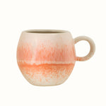 Small round mug with handle in a orange and netrual reactive glaze.